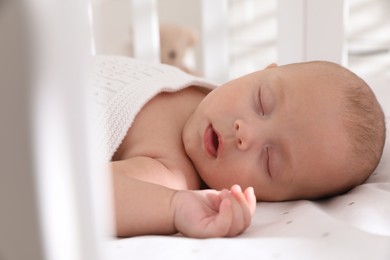 Photo of Cute little baby sleeping in crib, closeup