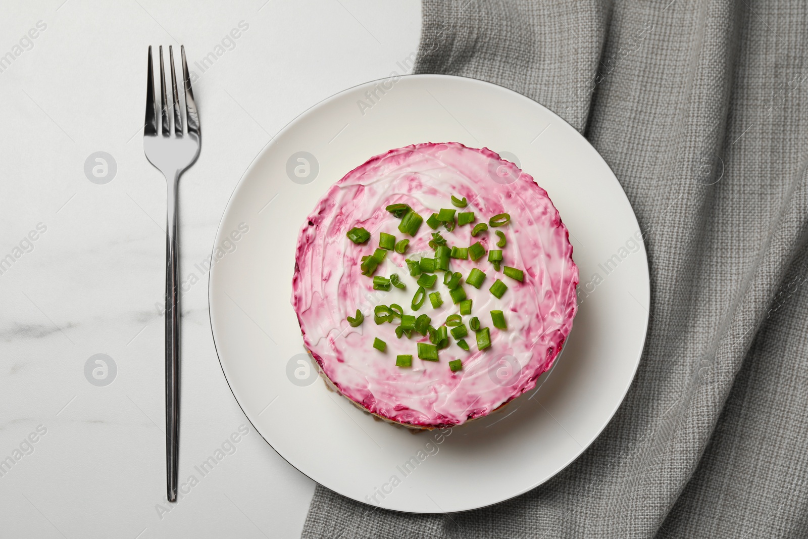 Photo of Herring under fur coat salad served on white table, flat lay. Traditional Russian dish