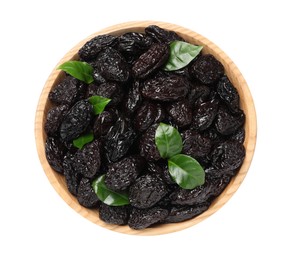 Photo of Wooden bowl with sweet dried prunes and green leaves isolated on white, top view