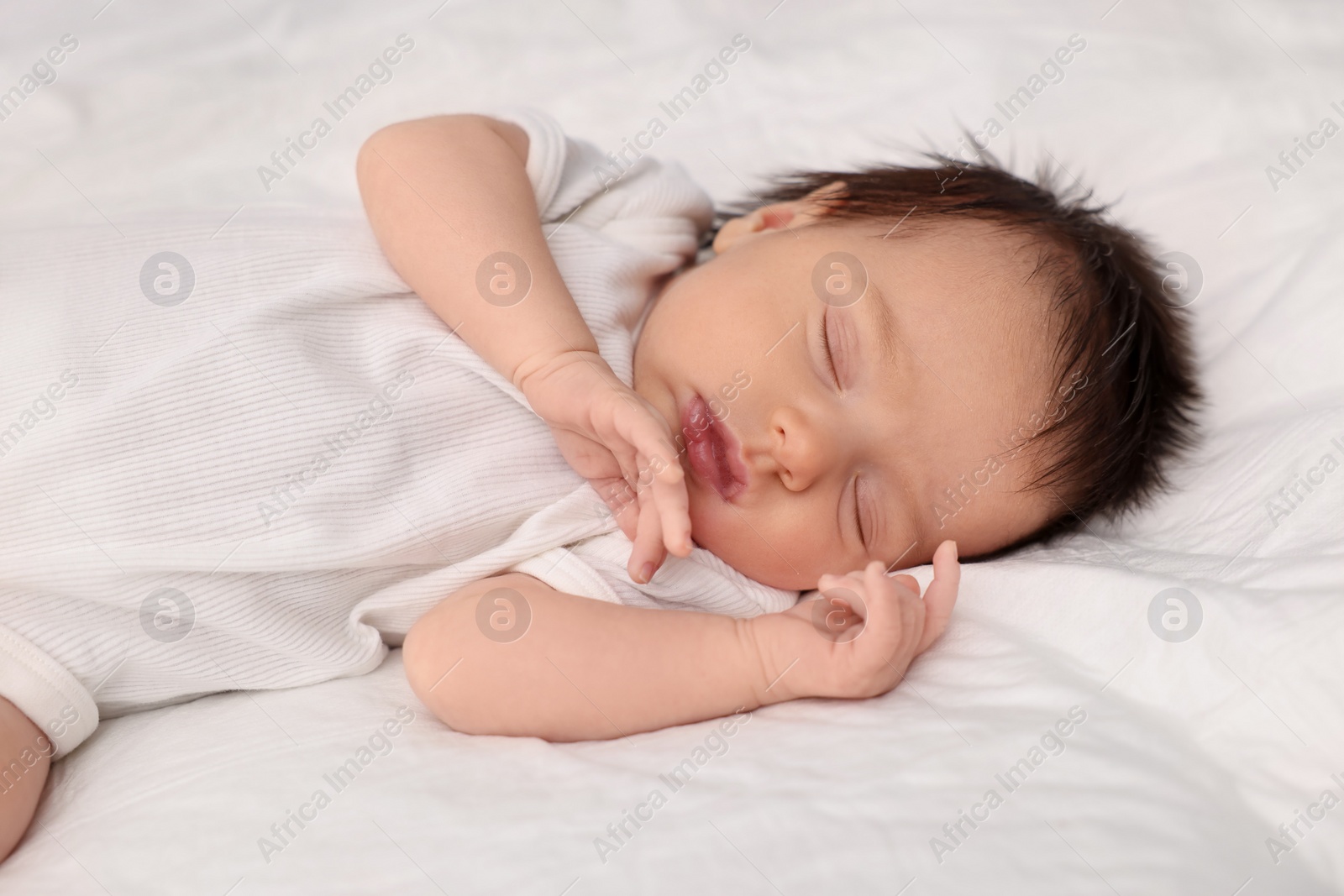 Photo of Cute newborn baby sleeping on white bed