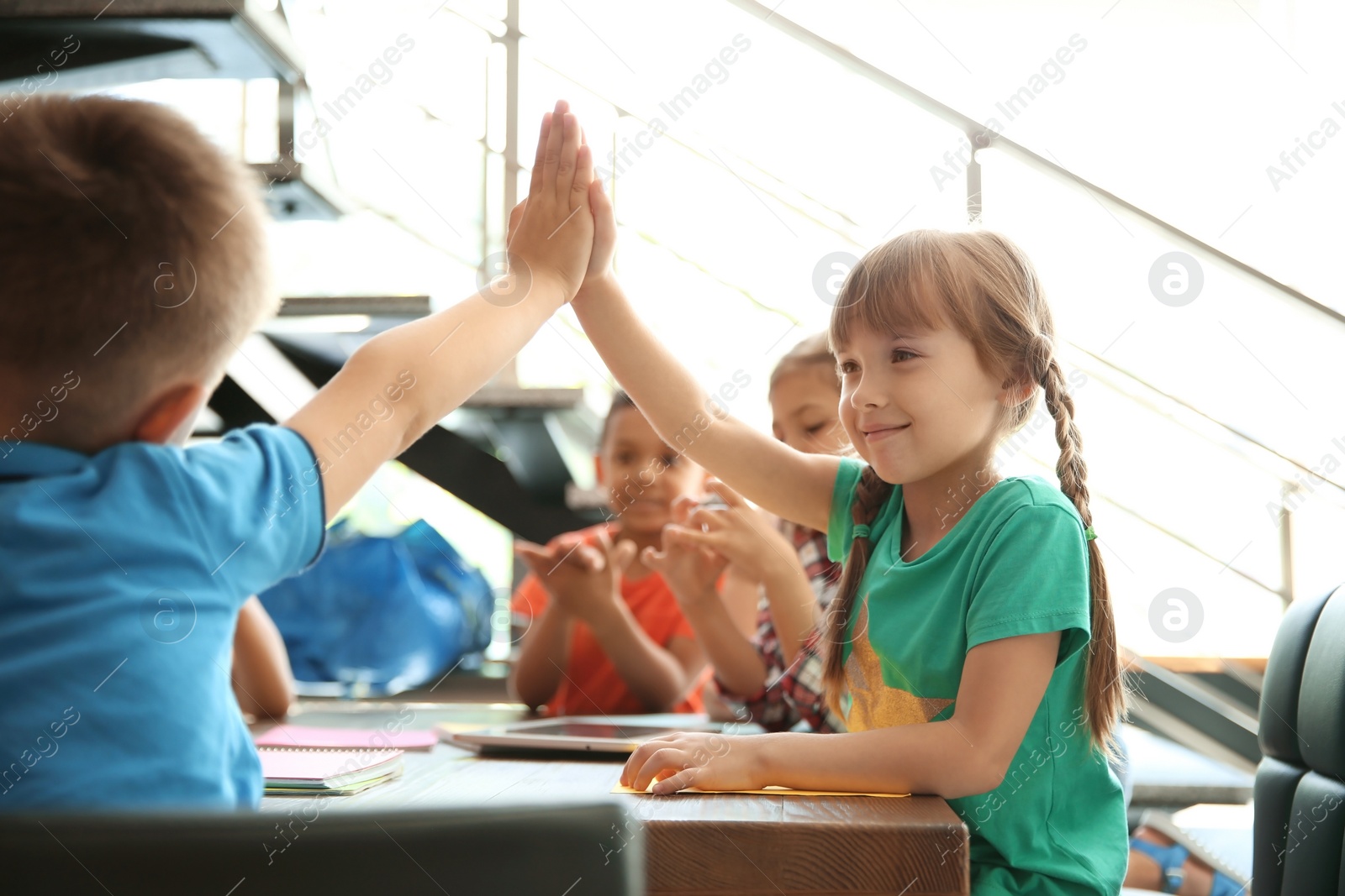 Photo of Little children putting their hands together indoors. Unity concept