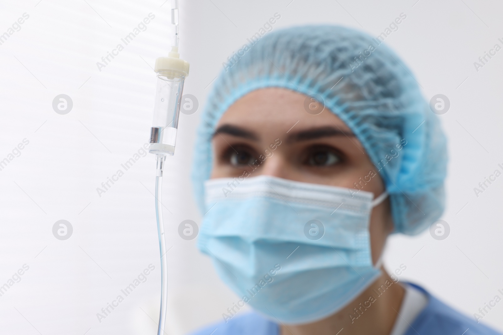 Photo of Setting up IV drip. Nurse on blurred background, selective focus