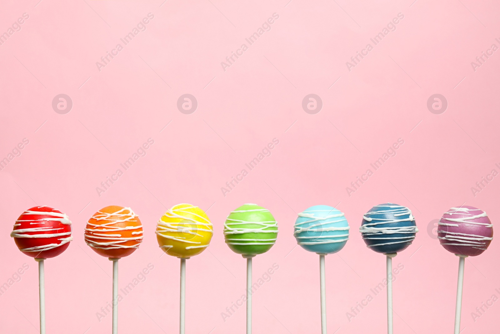 Photo of Rainbow made of delicious cake pops on color background. Space for text