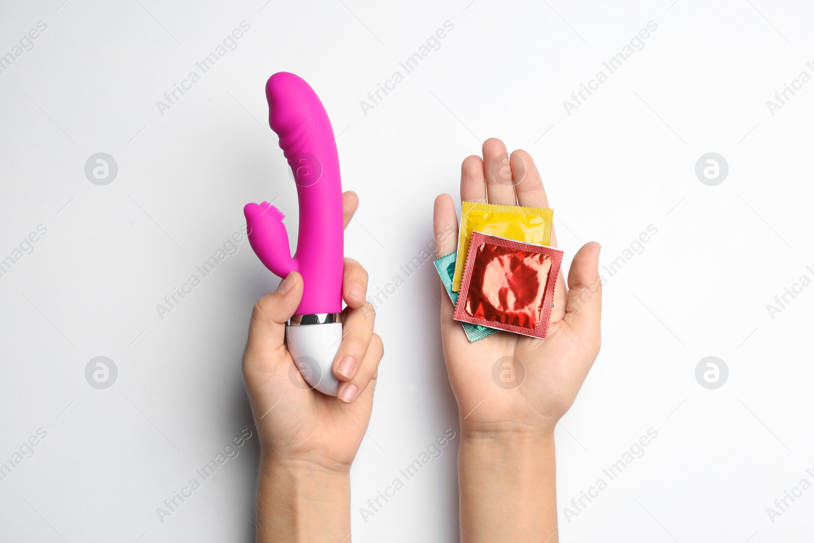 Photo of Woman with vibrator and condoms on white background, top view. Sex game