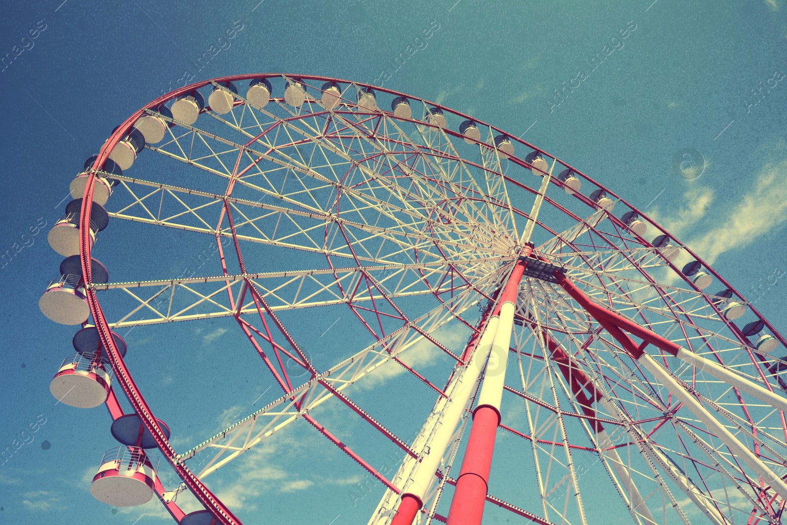 Image of Beautiful large Ferris wheel against blue sky, low angle view