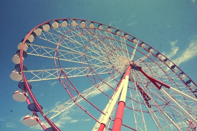 Image of Beautiful large Ferris wheel against blue sky, low angle view