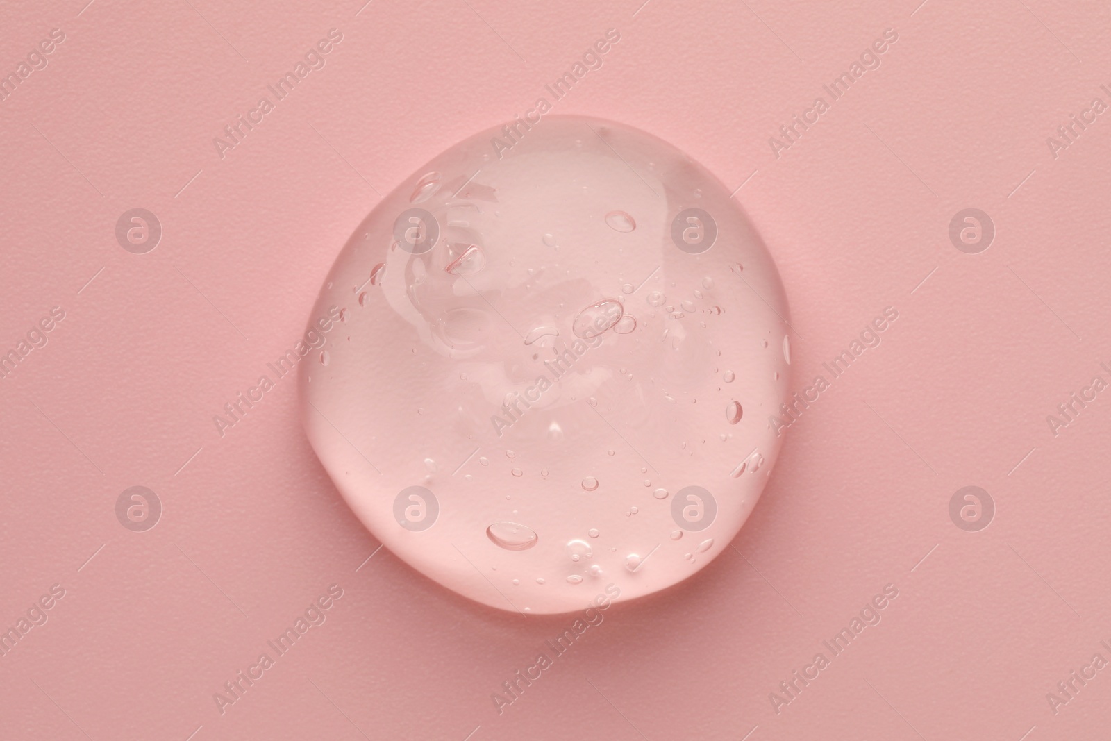 Photo of Sample of clear cosmetic gel on pink background, top view