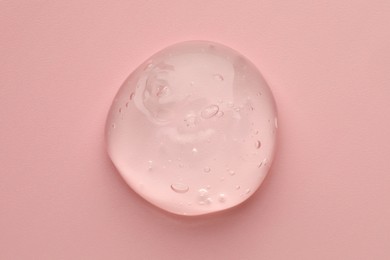 Photo of Sample of clear cosmetic gel on pink background, top view