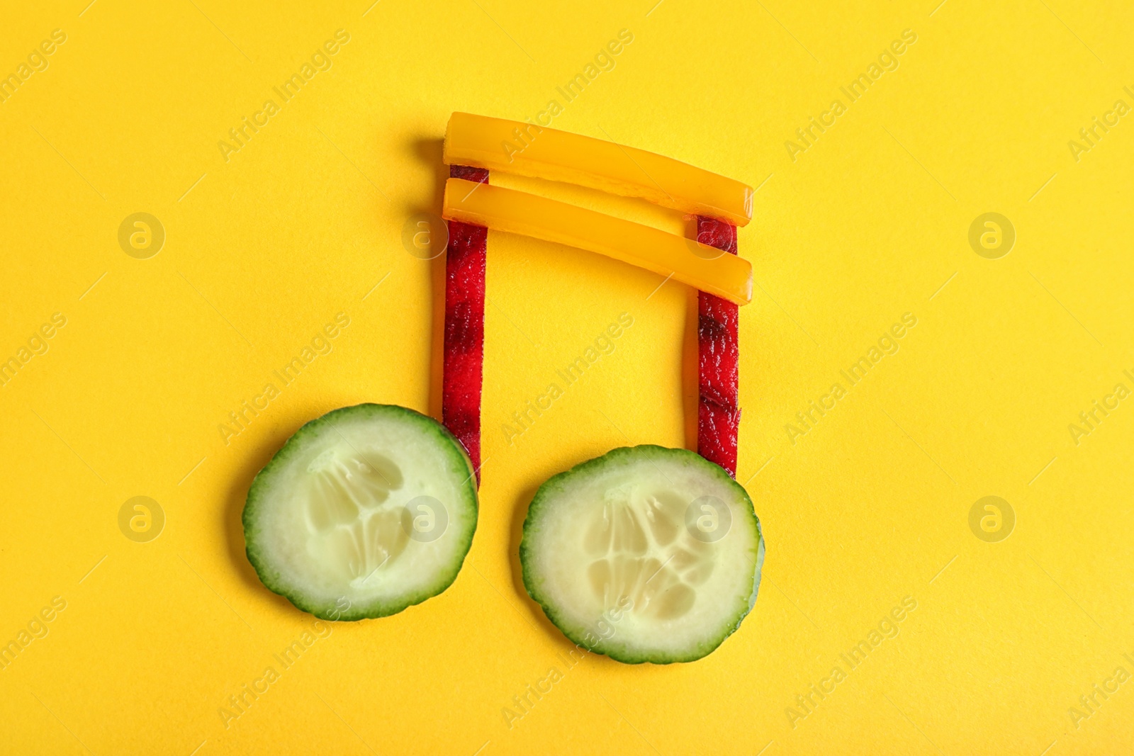 Photo of Musical note made of vegetables on color background, top view