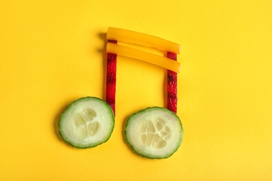Musical note made of vegetables on color background, top view