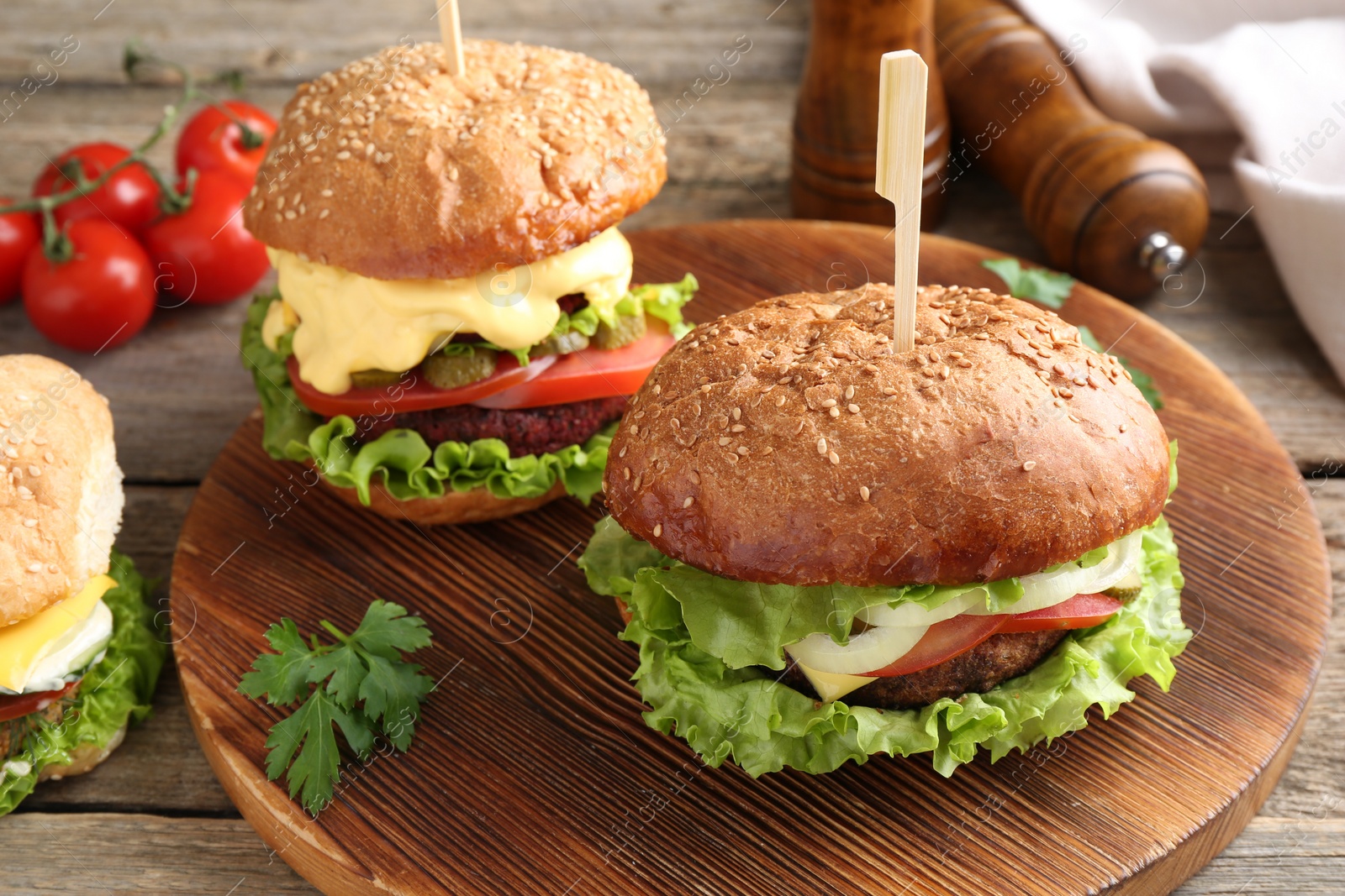 Photo of Delicious vegetarian burgers served on wooden table