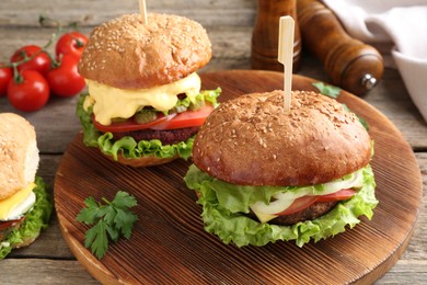 Photo of Delicious vegetarian burgers served on wooden table