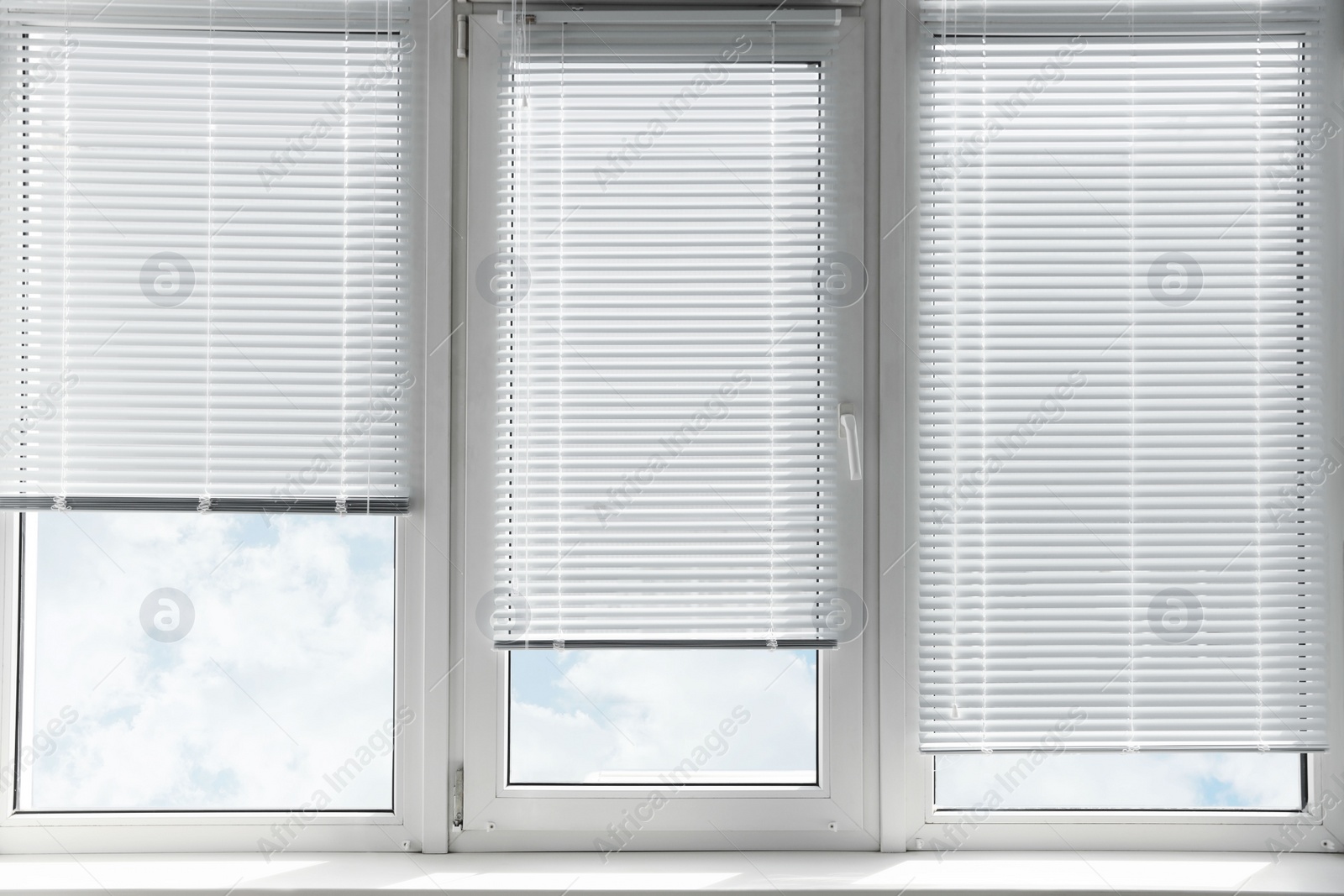 Photo of Stylish window with horizontal blinds in room