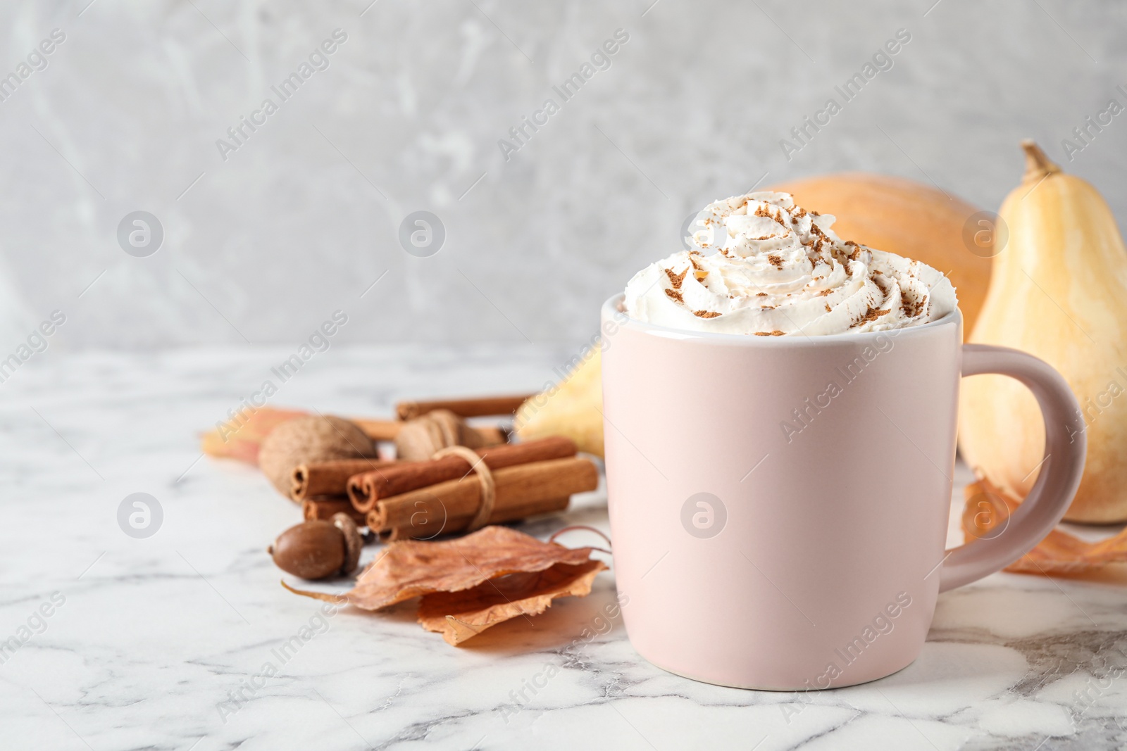 Photo of Cup with tasty pumpkin spice latte on white marble table. Space for text