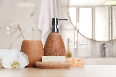 Image of Bath accessories. Different personal care products and flower on wooden table in bathroom, space for text