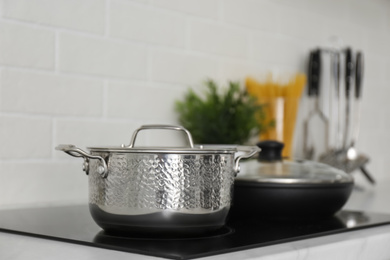 Saucepot and frying pan on induction stove in kitchen