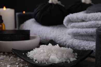 Spa composition. Sea salt and towels on table, closeup