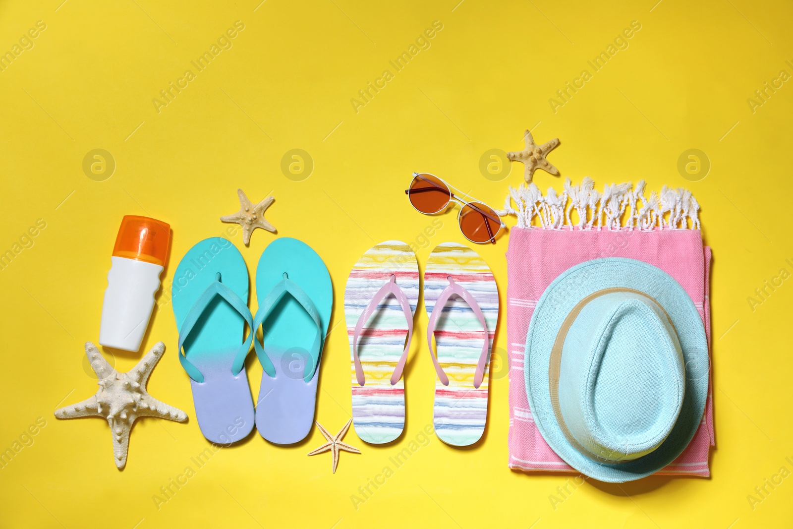 Photo of Flat lay composition with summer beach accessories on yellow background. Space for text