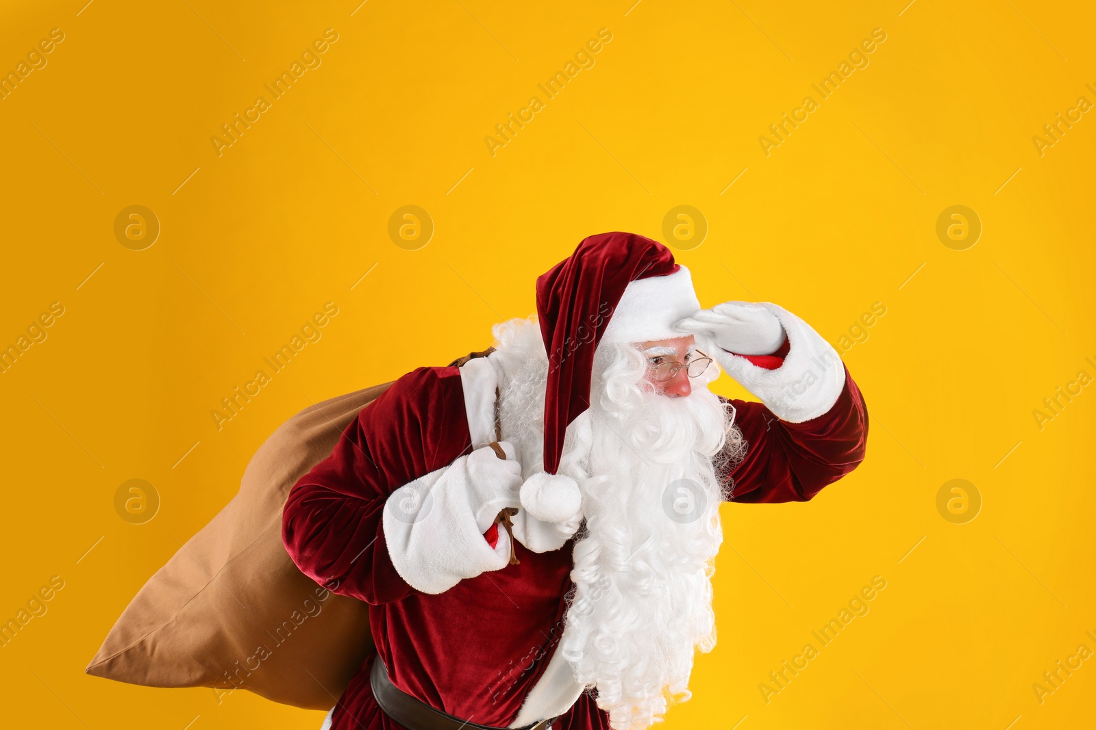 Photo of Portrait of Santa Claus with sack on yellow background