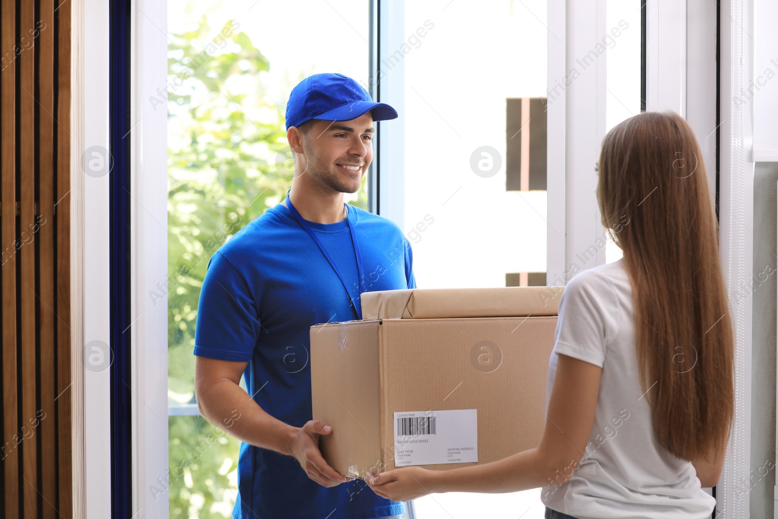 Photo of Woman receiving parcels from courier on doorstep