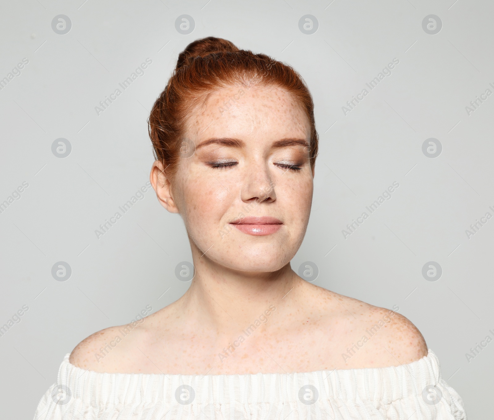 Photo of Portrait of young woman with beautiful face on grey background