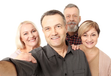 Group of happy senior people taking selfie on white background