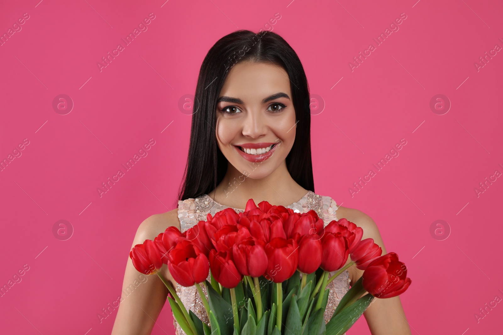 Photo of Happy woman with red tulip bouquet on pink background. 8th of March celebration