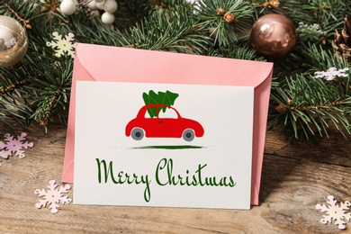 Image of Greeting card with text Merry Christmas on wooden table, closeup