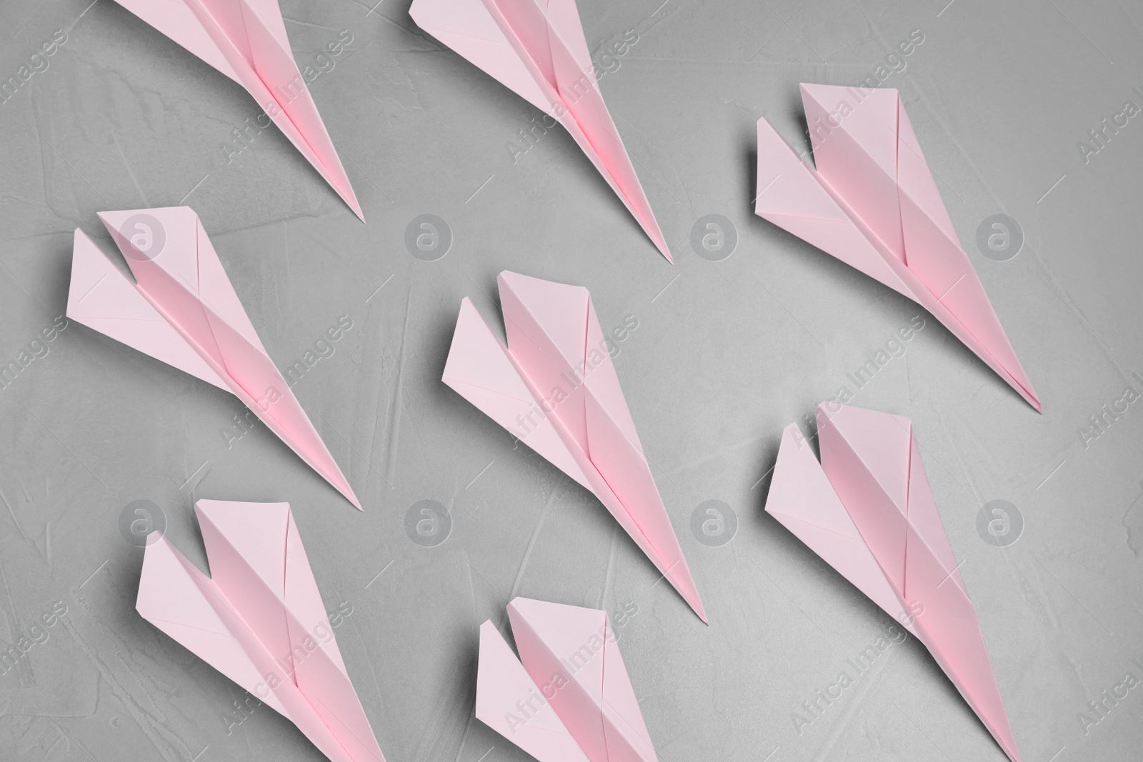 Photo of Many handmade paper planes on light grey table, flat lay