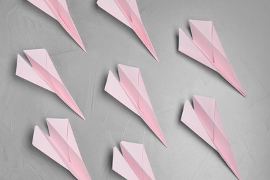 Photo of Many handmade paper planes on light grey table, flat lay