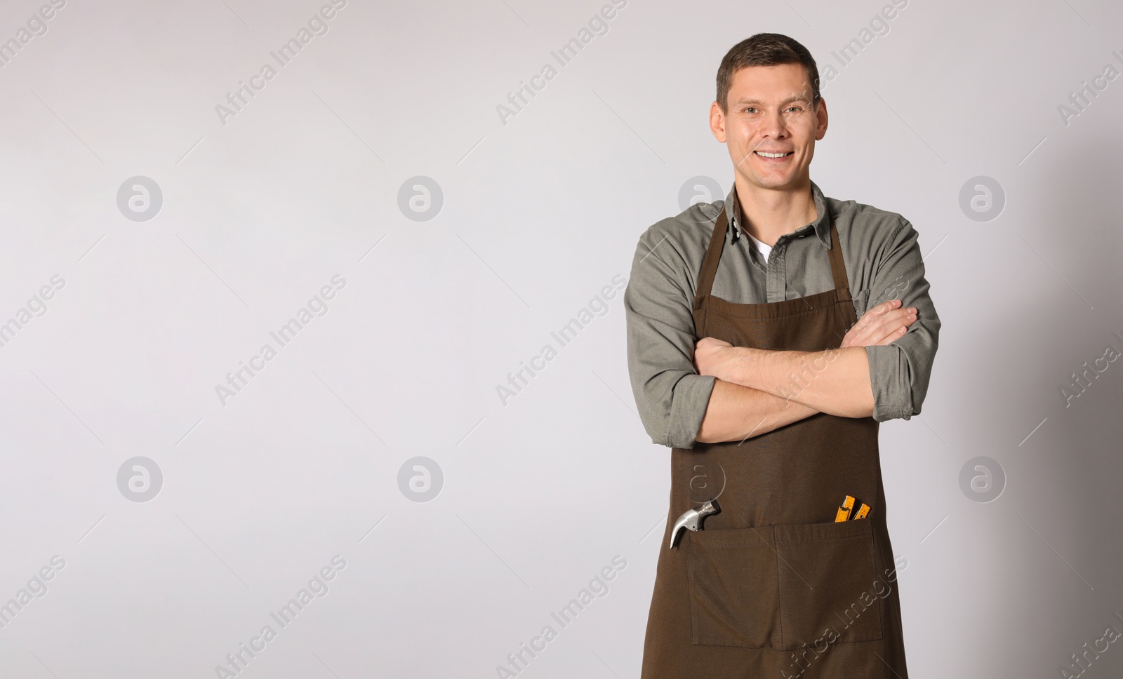 Photo of Handsome carpenter on light grey background. Space for text