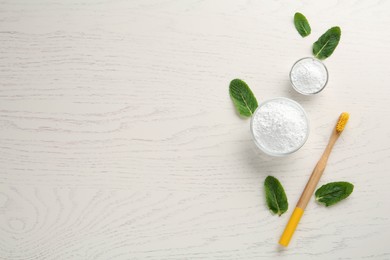 Photo of Tooth powder, brush and mint on white wooden table, flat lay. Space for text