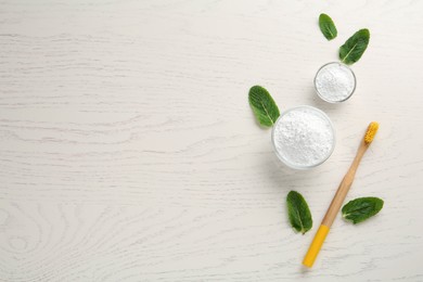 Tooth powder, brush and mint on white wooden table, flat lay. Space for text