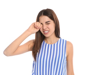 Young woman rubbing eye on white background. Annoying itch