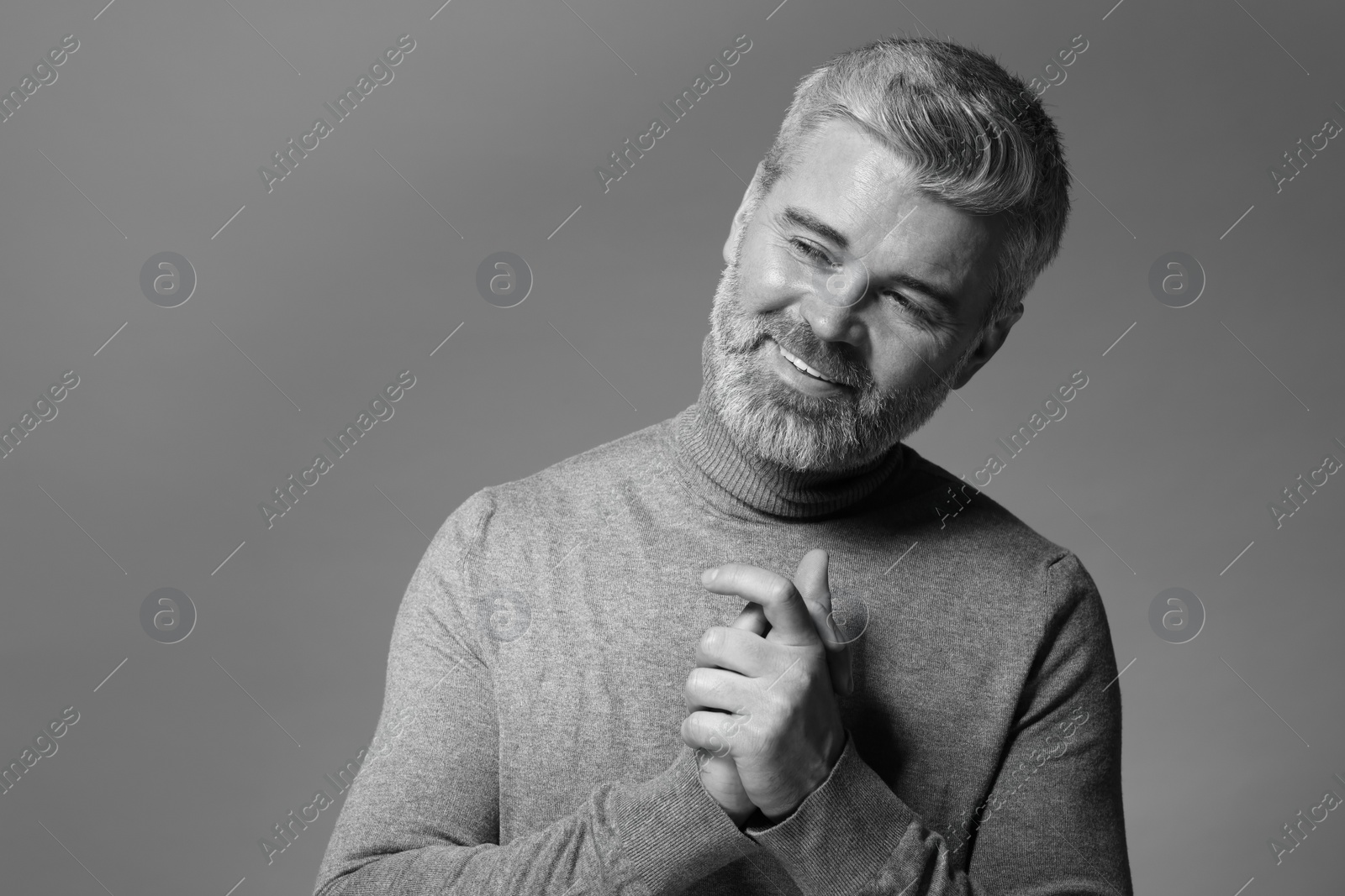 Photo of Portrait of smiling man on grey background. Black and white effect