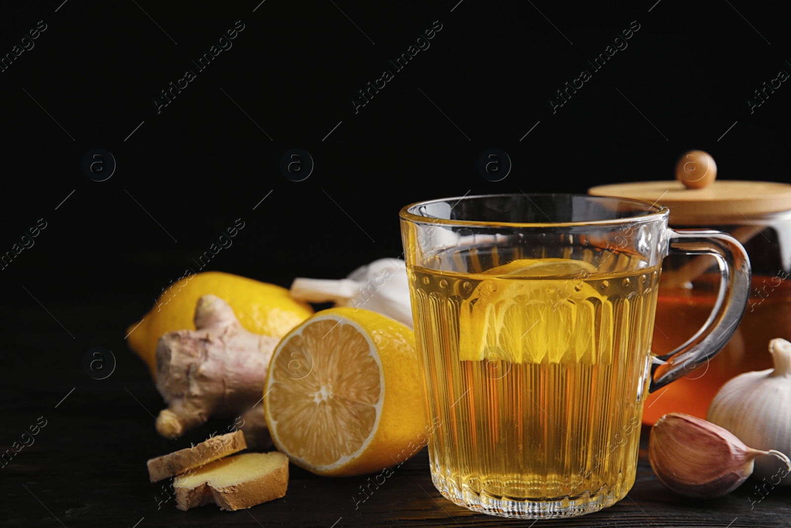 Photo of Composition with cold remedies on black wooden table. Sore throat treatment