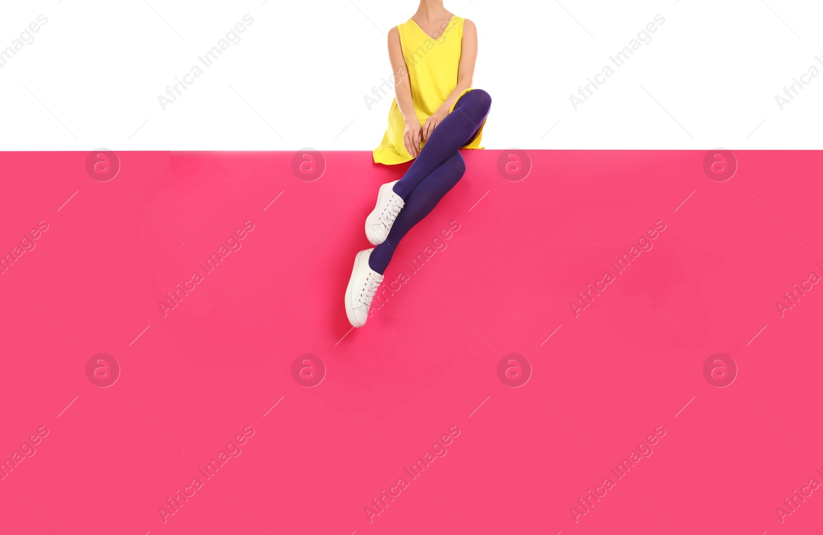 Photo of Woman wearing purple tights and stylish shoes sitting on color background, closeup