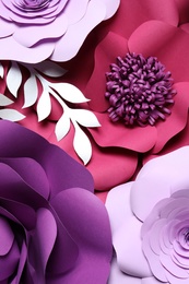 Photo of Different beautiful flowers and branches made of paper as background, top view