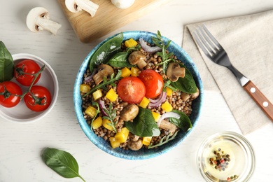 Flat lay composition with tasty buckwheat porridge on white wooden table