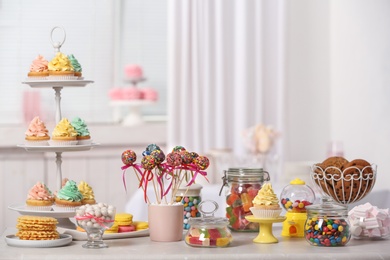 Photo of Candy bar with different sweets on white table against blurred background