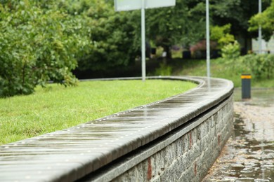 Photo of Wet bench on city street. Rainy weather