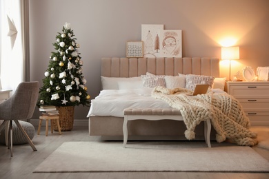 Beautiful decorated Christmas tree in bedroom interior