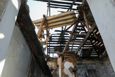 Photo of Ruined house with broken roof after strong earthquake, low angle view