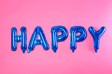 Photo of Word HAPPY made of blue foil balloon letters on pink background