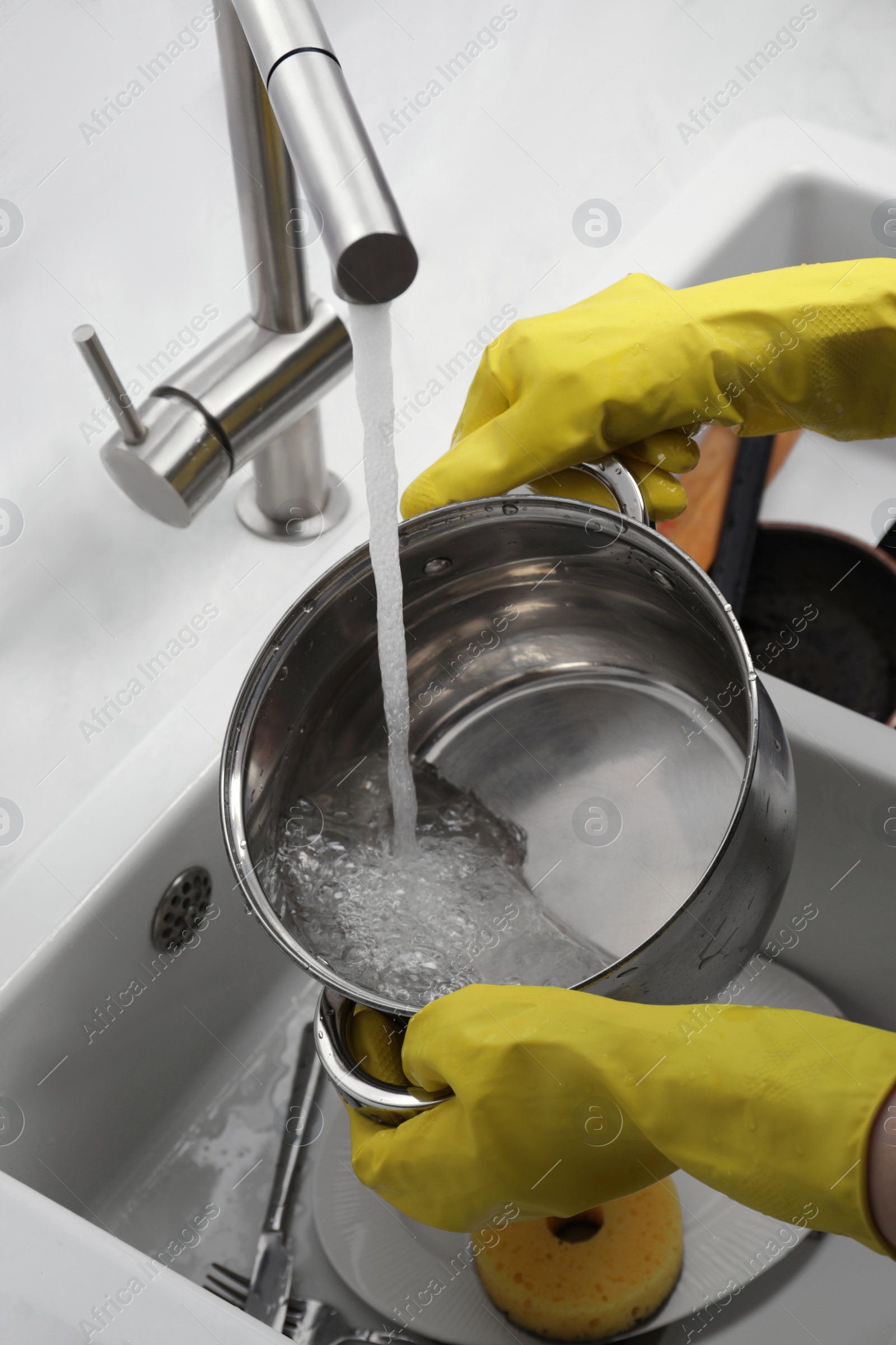 Photo of Woman washing dirty dishes in kitchen sink, closeup