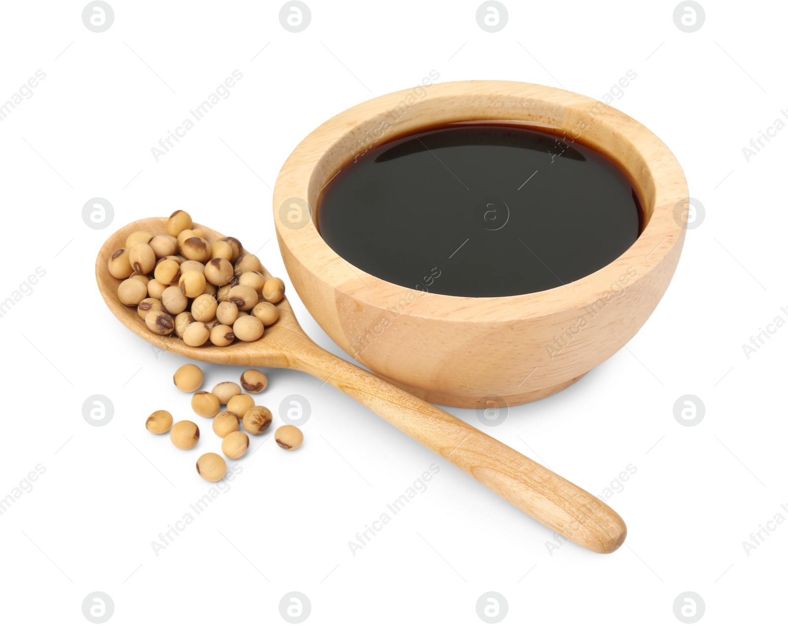 Photo of Tasty soy sauce in bowl, soybeans and spoon isolated on white