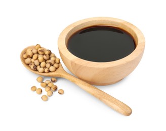 Tasty soy sauce in bowl, soybeans and spoon isolated on white