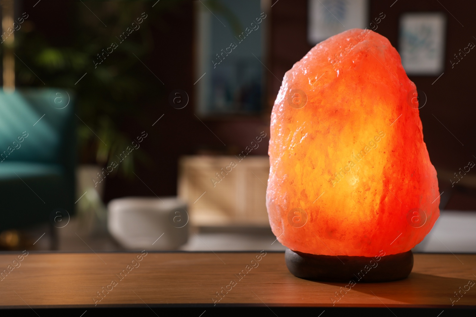 Photo of Himalayan salt lamp on wooden table indoors, space for text