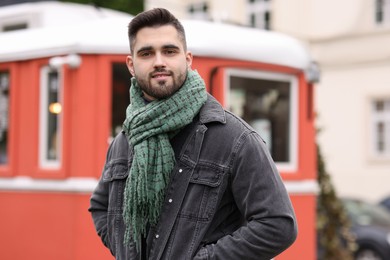 Handsome man in warm scarf on city street