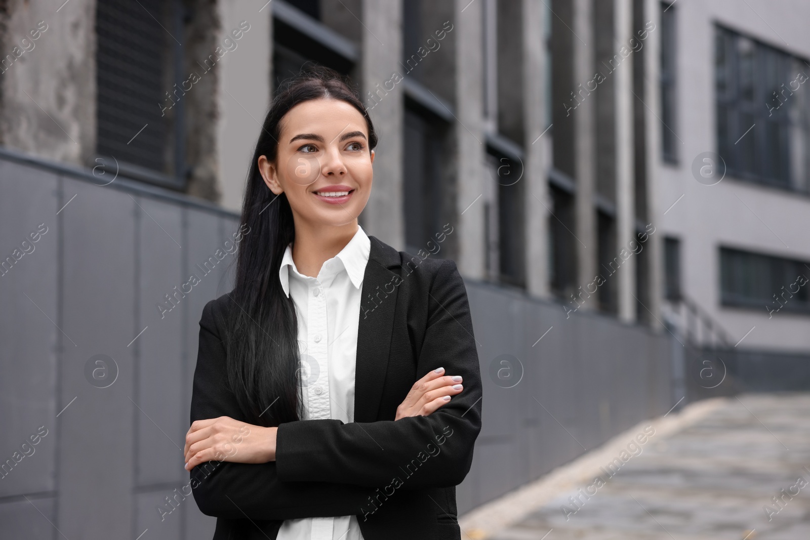 Photo of Portrait of smiling woman with crossed arms outdoors, space for text. Lawyer, businesswoman, accountant or manager